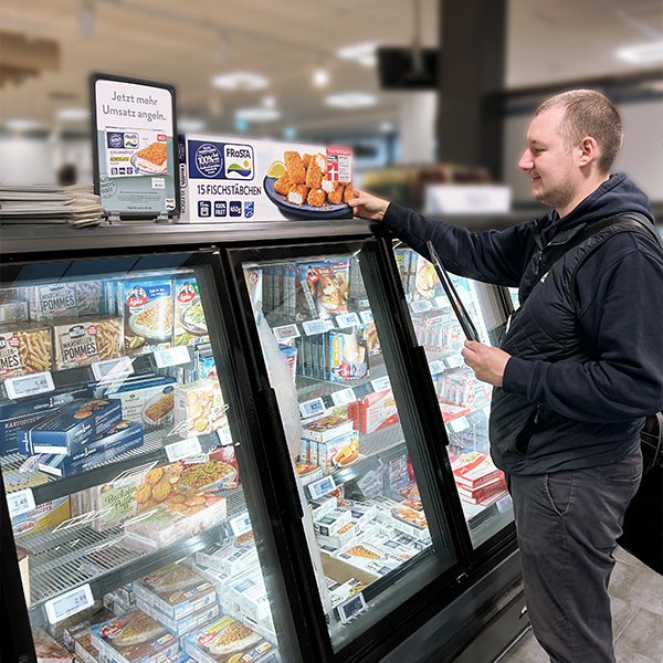 Petri Außendienstmitarbeiter mit Produkten von FRoSTA im Markt